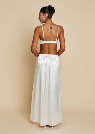 Back view of bride wearing white satin bralette and maxi skirt 