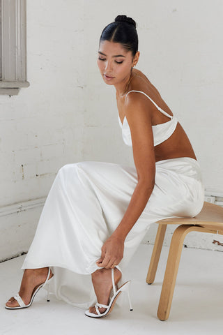 Bride wearing white satin bralette and maxi skirt 