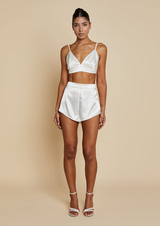 Front view of bride wearing satin bralette and mini short